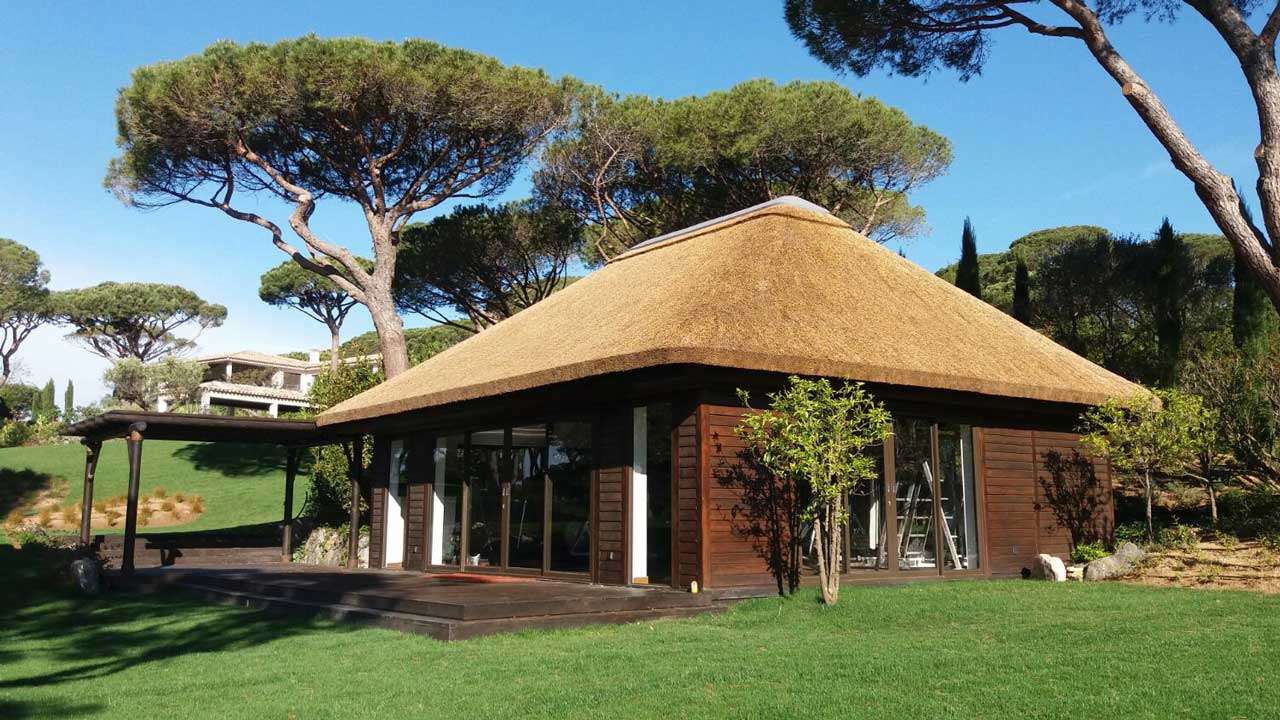 Thatched gymnasium cabin with timber cladding decking in St Tropez and pergola